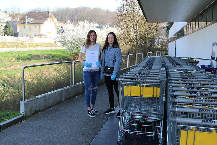 Möchten helfen, aber niemand meldet sich: Kim Schaller und Natalia Castro Castell beim Flyer-Verteilen beim Aldi in Niederlenz. Foto: Carolin Frei