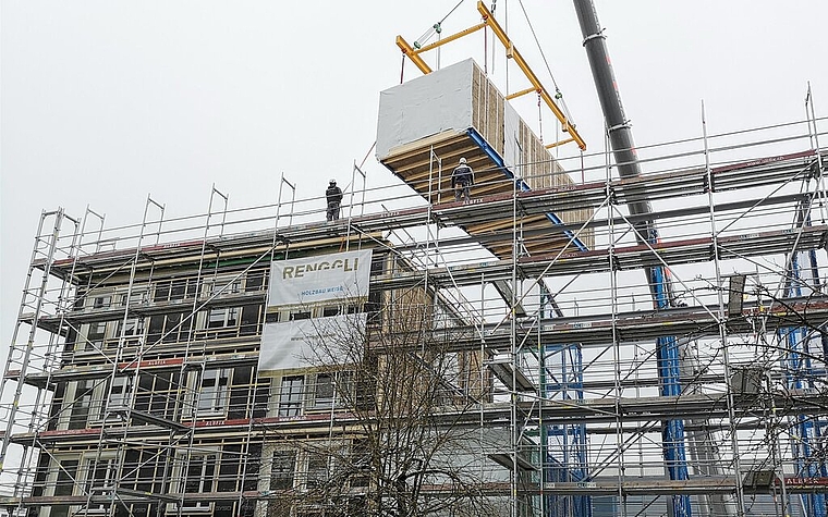 <em>Fertig vormontierte Zimmermodule «fliegen» ins Stahlgerüst:</em> Innovatives Wohnprojekt «Hello Lenzburg» im Westquartier. Foto: Fritz Thut