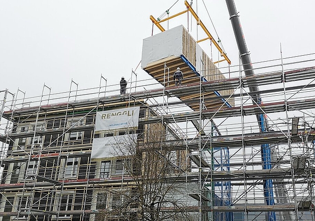 <em>Fertig vormontierte Zimmermodule «fliegen» ins Stahlgerüst:</em> Innovatives Wohnprojekt «Hello Lenzburg» im Westquartier. Foto: Fritz Thut