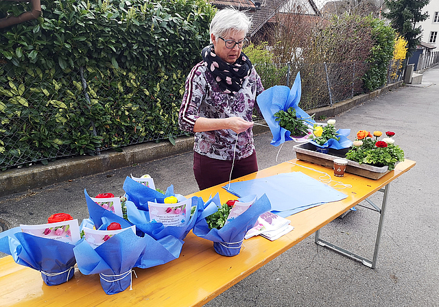 Schön verpackt und mit einem Gruss der Gemeinde versehen: Helferin beim Zusammenstellen eines Birrwiler Blumengrusses. Foto: Fritz Thut
