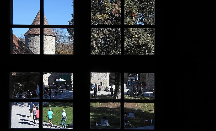<em>Blick aus dem Hinteren Schloss:</em> Läufer umrunden die Linde im Schlosshof.
