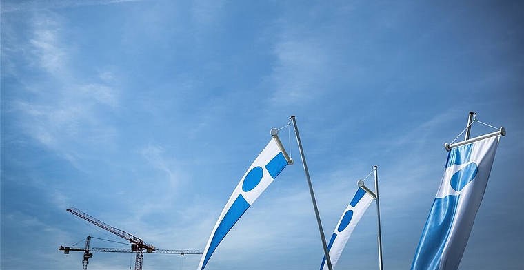 <em>Bauliche Entwicklung in Leitbild und Legislaturzielen nicht erwähnt:</em> Krane und Lenzburger Fahnen unter blauem Himmel. Foto: Chris Iseli