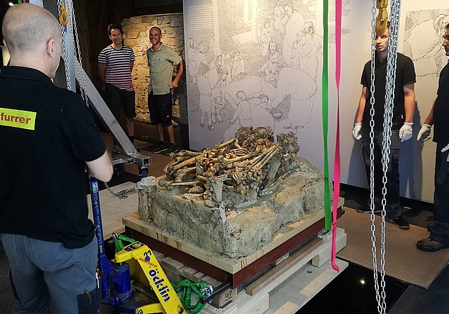 <em>Präzisionsarbeit:</em> Transportspezialisten platzieren ein Steinkistengrab aus der Jungsteinzeit im neuen Museum Burghalde. Foto: Fritz Thut