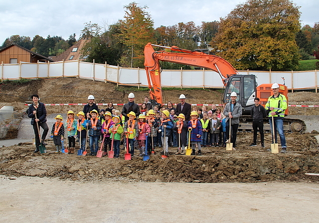 Die Freude über den lang ersehnten Baustart ist unübersehbar: Endlich konnte der Spatenstich mit Kindergärtlern, Schülern, Lehrpersonen, Architekten, Bauleitung und Gemeindeammann Max Härri (Mitte) vollzogen werden. Foto: Carolin Frei