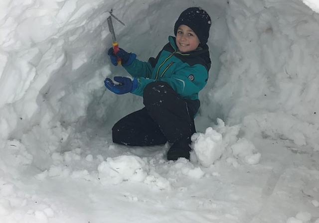 Eingeschneit und schulfrei: Lionel freuts, voller Eifer zimmert er sich mit Hilfe der Eltern einen Iglu.
