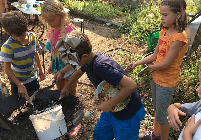 <em>Gärtnern macht offensichtlich Spass: </em>Die Kinder pflanzen mit Begeisterung Gemüse, Kräuter und Blumen an. Foto: zvg