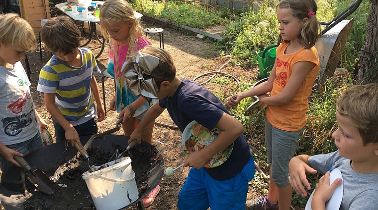 <em>Gärtnern macht offensichtlich Spass: </em>Die Kinder pflanzen mit Begeisterung Gemüse, Kräuter und Blumen an. Foto: zvg