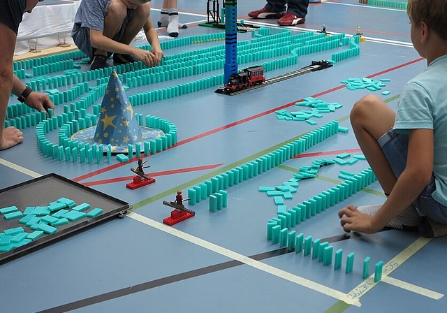 <em>Konzentriert bei der Sache: </em>Jung und Alt beim Dominoaufbau. Foto: zvg