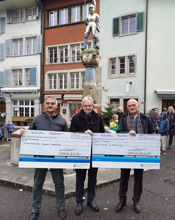 <em>Zwei Schecks über 5000 Franken:</em> Hanspeter Gehrig (Chlausklöpfer), Fischessen-OK-Präsident Sergio Caneve und Dieter Weber (Kantorei). Foto: Fritz Thut