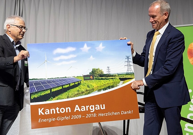 <em>Eine speziell gestaltete Tourismustafel zum Abschied:</em> Werner Leuthard, Abteilungsleiter Energie im kantonalen Departement Bau, Verkehr und Umwelt, überreicht Energie-Gipfel-Initiant und -Organisator Dieter Schäfer ein originelles Geschenk.