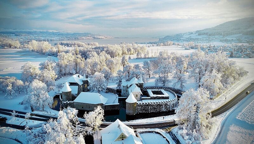 Unter einer dicken Schneedecke: Schloss Hallwyl von Norden her mit dem Hallwilersee im Hintergrund. Foto: Pascal Meier
