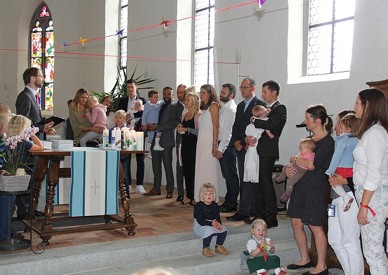 <em>Ein feierlicher Moment:</em> Eltern, Täuflinge, Geschwister, Gotten und Göttis warten auf die Taufe. Foto: AG