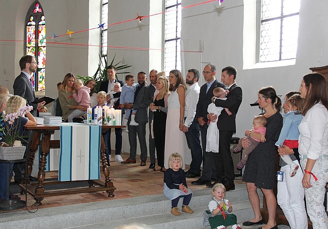 <em>Ein feierlicher Moment:</em> Eltern, Täuflinge, Geschwister, Gotten und Göttis warten auf die Taufe. Foto: AG