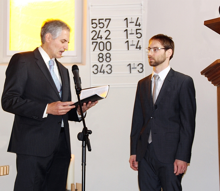 Neupfarrer Andreas Ladner: Er hört sich das von Dekan Philipp Nanz (li.) vorgelesene Gelübde an. Foto: Alfred Gassmann