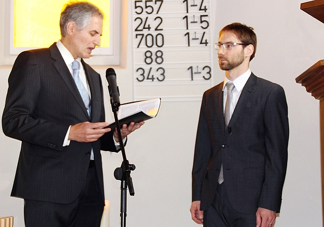 Neupfarrer Andreas Ladner: Er hört sich das von Dekan Philipp Nanz (li.) vorgelesene Gelübde an. Foto: Alfred Gassmann
