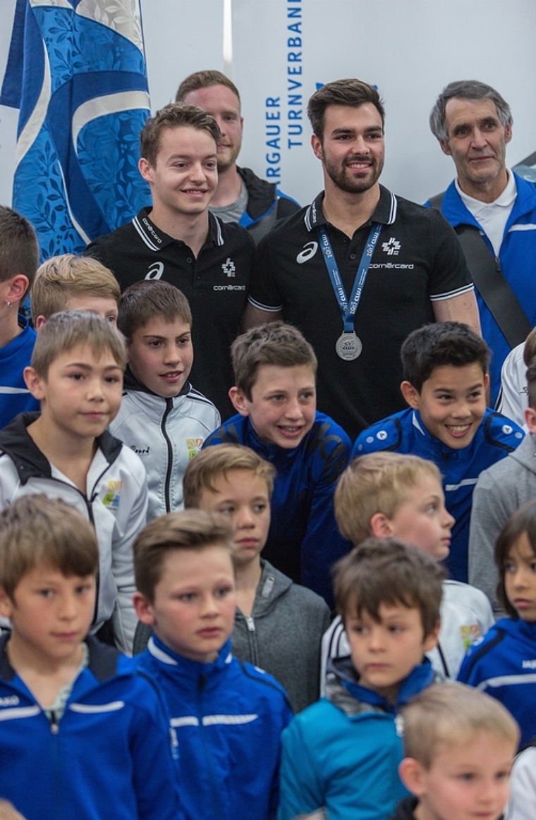 Posieren mit dem Nachwuchs: Christian Baumann und Oliver Hegi (in schwarzen Polo-Shirts) am Empfang im Turnzentrum Niederlenz. Foto: Chris Iseli