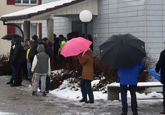 Schutz gegen Wind und Wetter: Unter Schirm und Dach verfolgen die Zuschauer den 50. Chlausklöpf-Wettbewerb in Hallwil. Foto: Andreas Walker