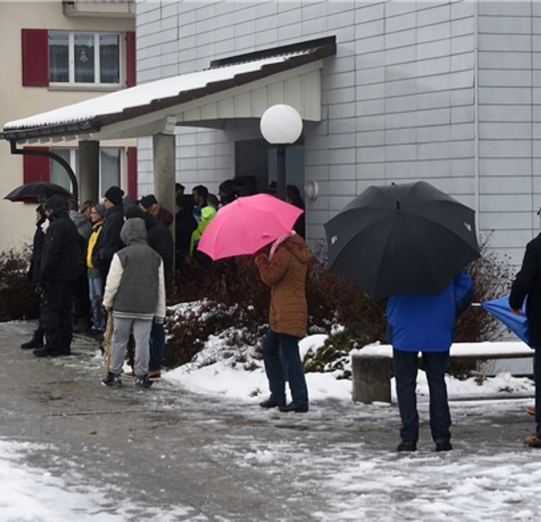 Schutz gegen Wind und Wetter: Unter Schirm und Dach verfolgen die Zuschauer den 50. Chlausklöpf-Wettbewerb in Hallwil. Foto: Andreas Walker