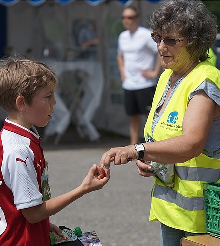<em>Eine von 150 Freiwilligen:</em> Helferin Vreni Blaser drückt einem Schüler nach dem Zieldurchlauf einen Apfel in die Hand. <em>Eine von 150 Freiwilligen:</em> Helferin Vreni Blaser drückt einem Schüler nach dem Zieldurchlauf einen Apfel in die Hand.