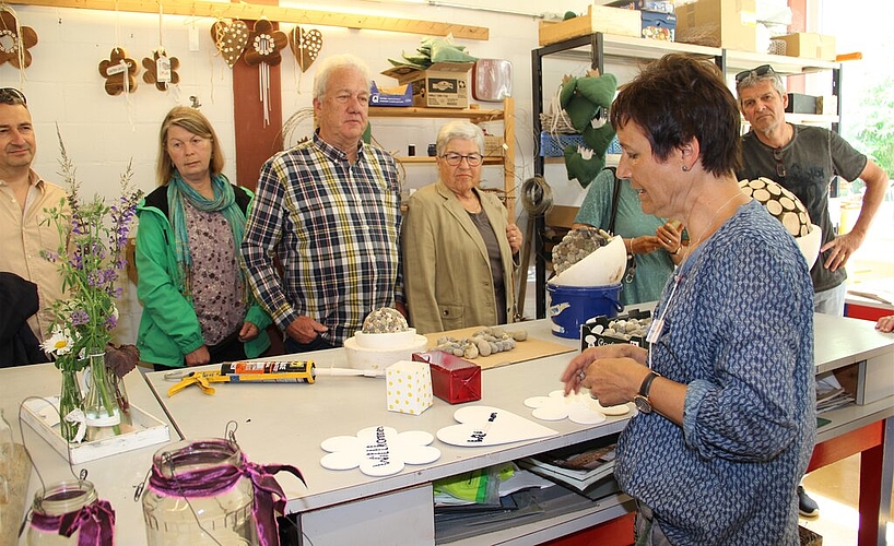 <em>Blick hinter die Kulissen:</em> Kathrin Leu (r.) erklärt den Besuchern, was sie im Atelier mit den Klienten alles herstellt – vieles aus Recycling-Material. Foto: Carolin Frey <em>Blick hinter die Kulissen:</em> Kathrin Leu (r.) erklärt den Besuchern, was sie im Atelier mit den Klienten alles herstellt – vieles aus Recycling-Material. Foto: Carolin Frey