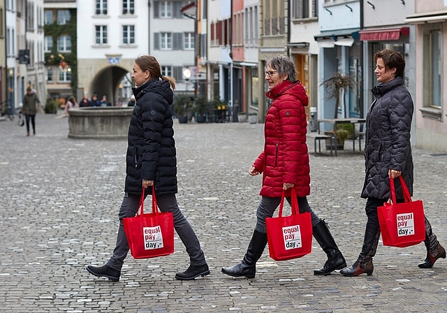 <em>Marschieren für Lohngleichheit:</em> Leandra Bruder, Gunhild Geiger und Denise Gunkel vom Business-and-Professional-Women-Club Lenzburg mit Equal-Pay-Day-Taschen in der Rathausgasse. Foto: zvg