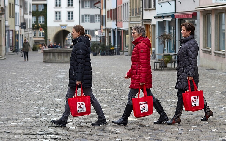 <em>Marschieren für Lohngleichheit:</em> Leandra Bruder, Gunhild Geiger und Denise Gunkel vom Business-and-Professional-Women-Club Lenzburg mit Equal-Pay-Day-Taschen in der Rathausgasse. Foto: zvg