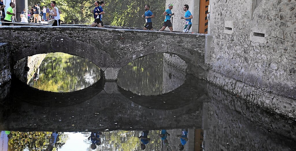 <em>Gespiegelt:</em> Teilnehmer am 44. Hallwilerseelauf auf der Zugangsbrücke zum Schloss Hallwyl.