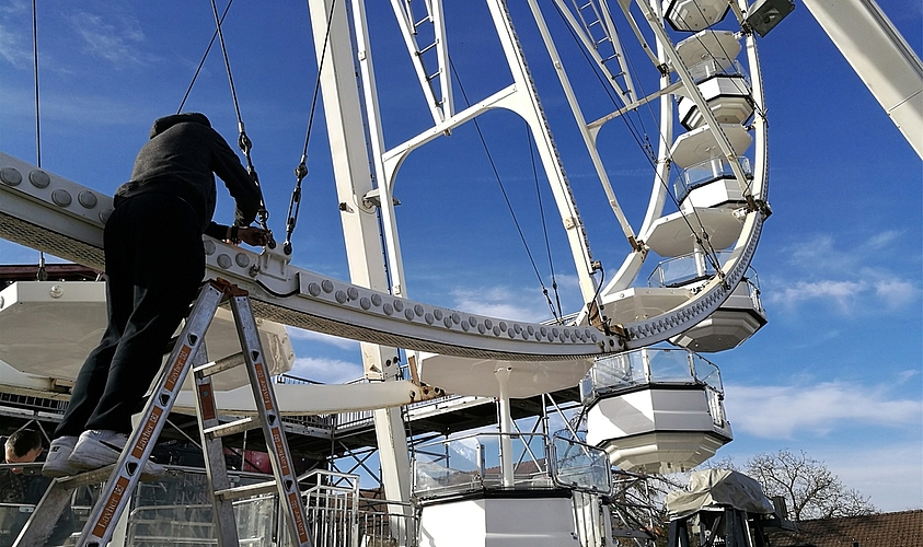 Letzter Schliff am Wahrzeichen der Ausstellung: Ein Arbeiter kontrolliert Verbindungen am Riesenrad auf dem Lenzburger Zeughausareal. Fotos: Fritz Thut
