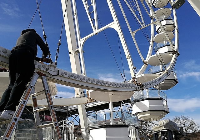 Letzter Schliff am Wahrzeichen der Ausstellung: Ein Arbeiter kontrolliert Verbindungen am Riesenrad auf dem Lenzburger Zeughausareal. Fotos: Fritz Thut
