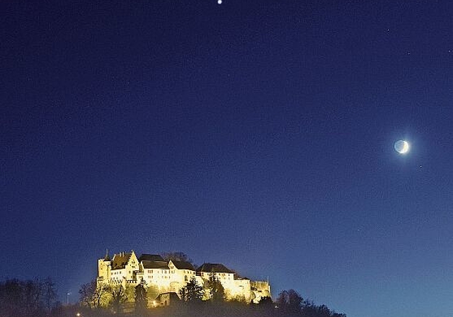 Eine stete Annäherung: Schloss Lenzburg mit Saturn (oben), Jupiter (Mitte) und Mond (rechts) am Abendhimmel, aufgenommen am 18. November. Die Planeten nähern sich immer mehr an und «verschmelzen» am 21. Dezember scheinbar zu einem Objekt. Foto: A