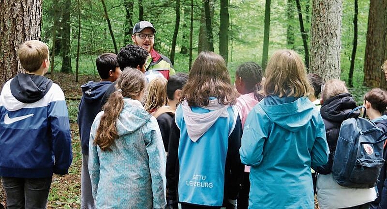 Lernen an der frischen Luft: Forstwart Pascal Hüssy instruiert die Kinder.Foto: Romi Schmid