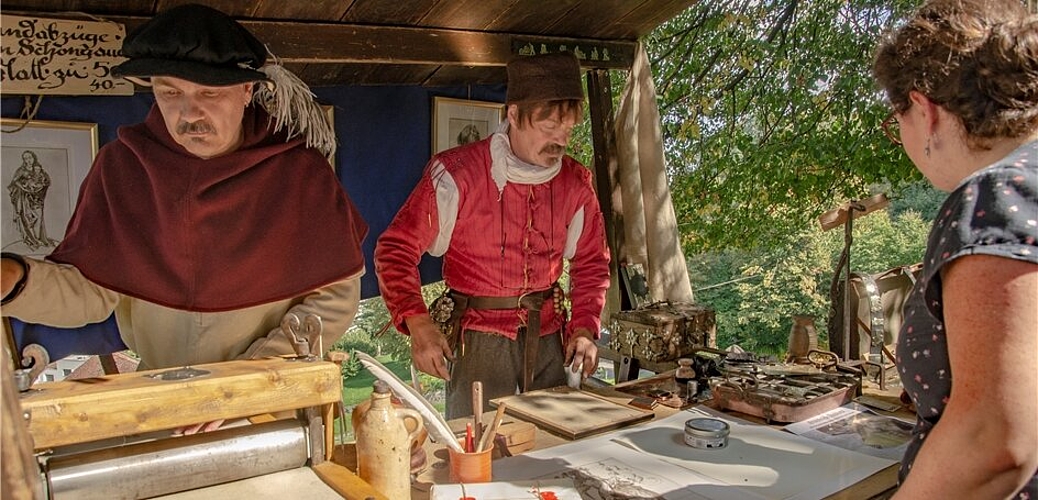 <em>Frisch ab Druckerpresse:</em> Adalbert Fässler und sein Bruder Maurus zeigten am Mittelaltermarkt eindrücklich, wie vor der Erfindung des modernen Buchdruckes durch Johannes Gutenberg im Jahre 1450 gedruckt wurde.<em> Fotos: Peter Winkelmann</em>