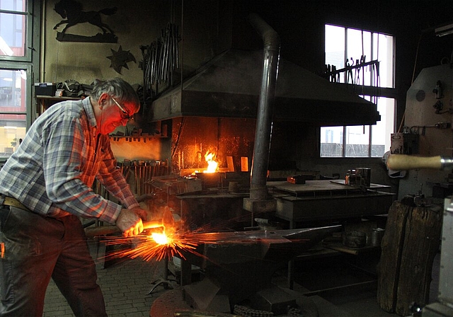 <em>In der Werkstatt am Mattenweg 28:</em> Der Kunstschmied Ueli Schneider formt die sieben glühenden Stahlplättchen eines künftigen Messers. Foto: Alfred Gassmann