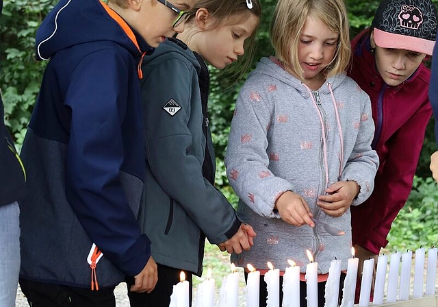 Symbolisches Bekämpfen eines Waldbrandes: Löffel für Löffel löschen die Kinder die brennenden Kerzen. Foto: Tanja Isler
