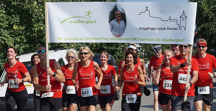 <em>Ein Bier auf das Jubiläum:</em> Die Jogginggruppe Baden gratulierte ihrem Mitglied Christian Frey zum Jubiläum. Die Dame ganz links lief tatsächlich mit einer Bierdose in der Hand ins Ziel. Foto: Ruedi Burkart