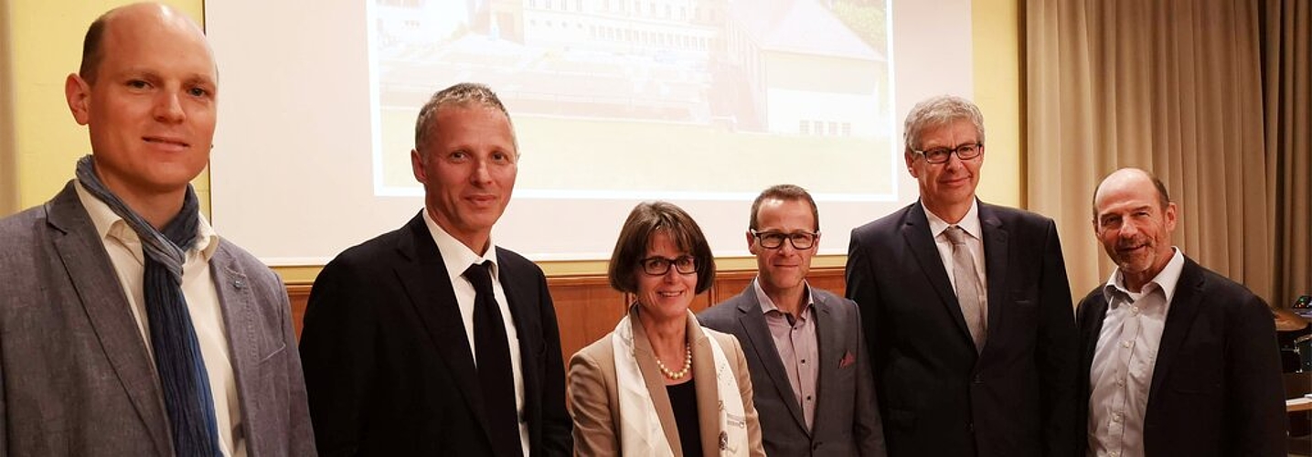 <em>Sie stehen hinter der Sanierung der Bleicherain-Schulanlage und vor einer Foto des Schulhauses:</em> Fabian von Gunten (Bauleiter), Benedikt Graf (Architekt), Monica Morgenthaler (Vertreterin BKS), Reto Kunz (Schulleiter), Daniel Mosimann (Stadta <em>Sie stehen hinter der Sanierung der Bleicherain-Schulanlage und vor einer Foto des Schulhauses:</em> Fabian von Gunten (Bauleiter), Benedikt Graf (Architekt), Monica Morgenthaler (Vertreterin BKS), Reto Kunz (Schulleiter), Daniel Mosimann (Stadtammann) und Heinz Binder (Musikschulleiter). Foto: Fritz Thut