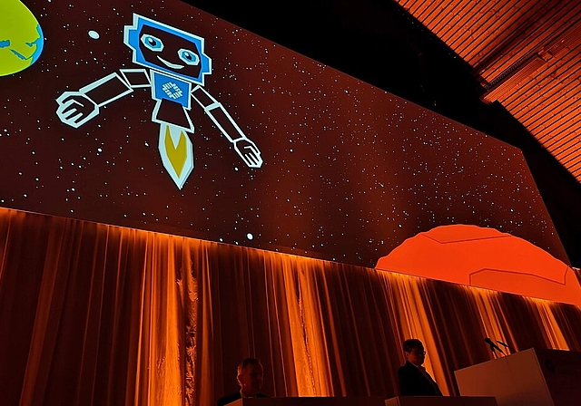 <em>Grüsse aus der Zukunft:</em> Der «Hypi-Bot» zeigte auf der Grossleinwand, wie das Bankgeschäft in 150 Jahren aussehen könnte, und stellte CEO Marianne Wildi in den Schatten. Foto: Fritz Thut