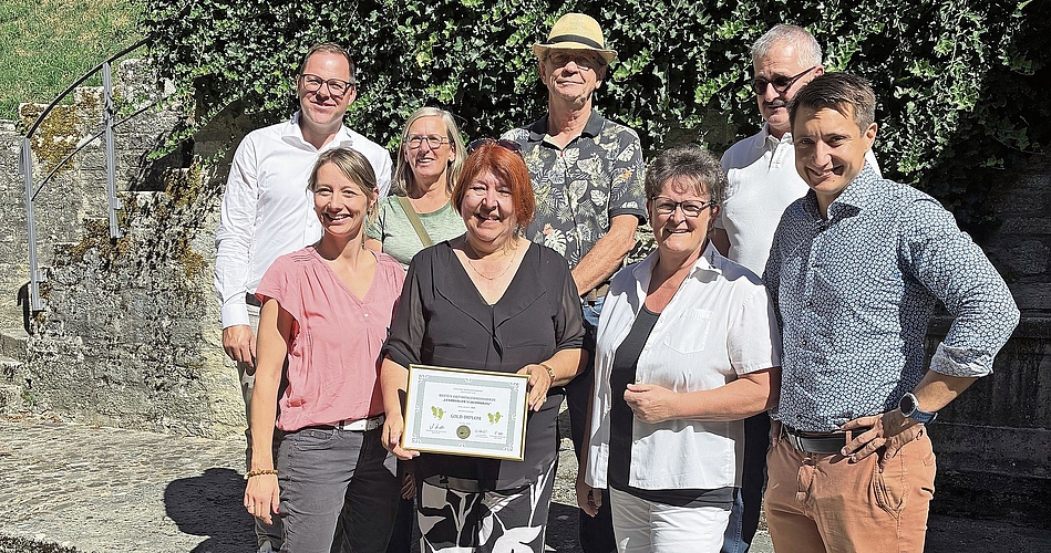 Corin Ballhaus nimmt das Golddiplom entgegen. Mit auf dem Bild Stadträtin Christina Roth, Milly Stöckli, Präsidentin des Ortsbürgerverbands Aargau, Stadtpräsident Andreas Schmid (vorn, von links). Grossrat Rolf Wehrli, OK-Präsident der Ortsbürgerweinprämierung, Marianne Plüss-Marmy, Werner Volkmar und Roger Strozzega, alle vom Vorstand der Ortsbürger-Rebbauern-Vereinigung (hinten, von links).Foto: zvg