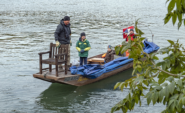 Keiner zu klein, Aarereiniger zu sein: Raphael (links) und llias (rechts) halfen kräftig mit, den grossen Holzstuhl aus dem Wasser zu fischen. Roger Wüest (vorne) und Max Sandmeier (hinten) brachten mit der «Barbara» Gegenstände ans Ufer, die im