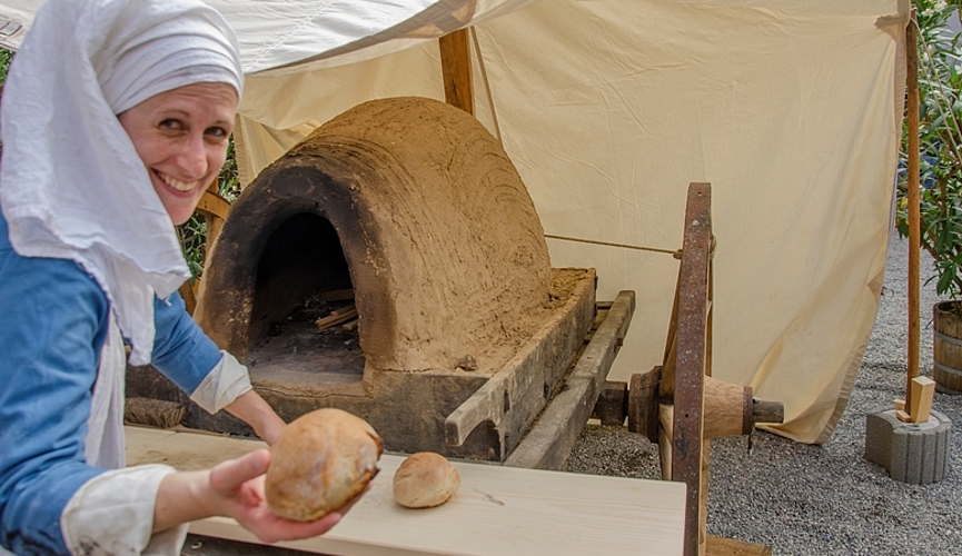 <em>Frisch aus dem Ofen schmeckts am besten:</em> Backfrau Eva Grädel holte herrlich warme Brötchen aus dem nachgebauten Lehmbackofen.