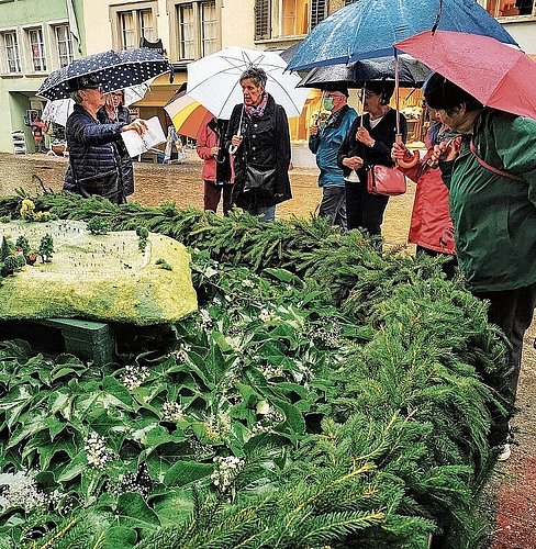 Unter Schirmen: Regen zum Start der donnerstäglichen Brunnenführungen. Foto: Fritz Thut
