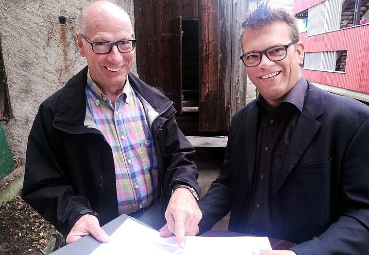 <em>Freuen sich auf die Reaktivierung des Wasserrades Bleiche:</em> Stadtrat und Industriekultur-Vereinspräsident Martin Stücheli und Architekt André Meier betrachten vor dem verdeckten Wasserrad die Pläne. Foto: Fritz Thut