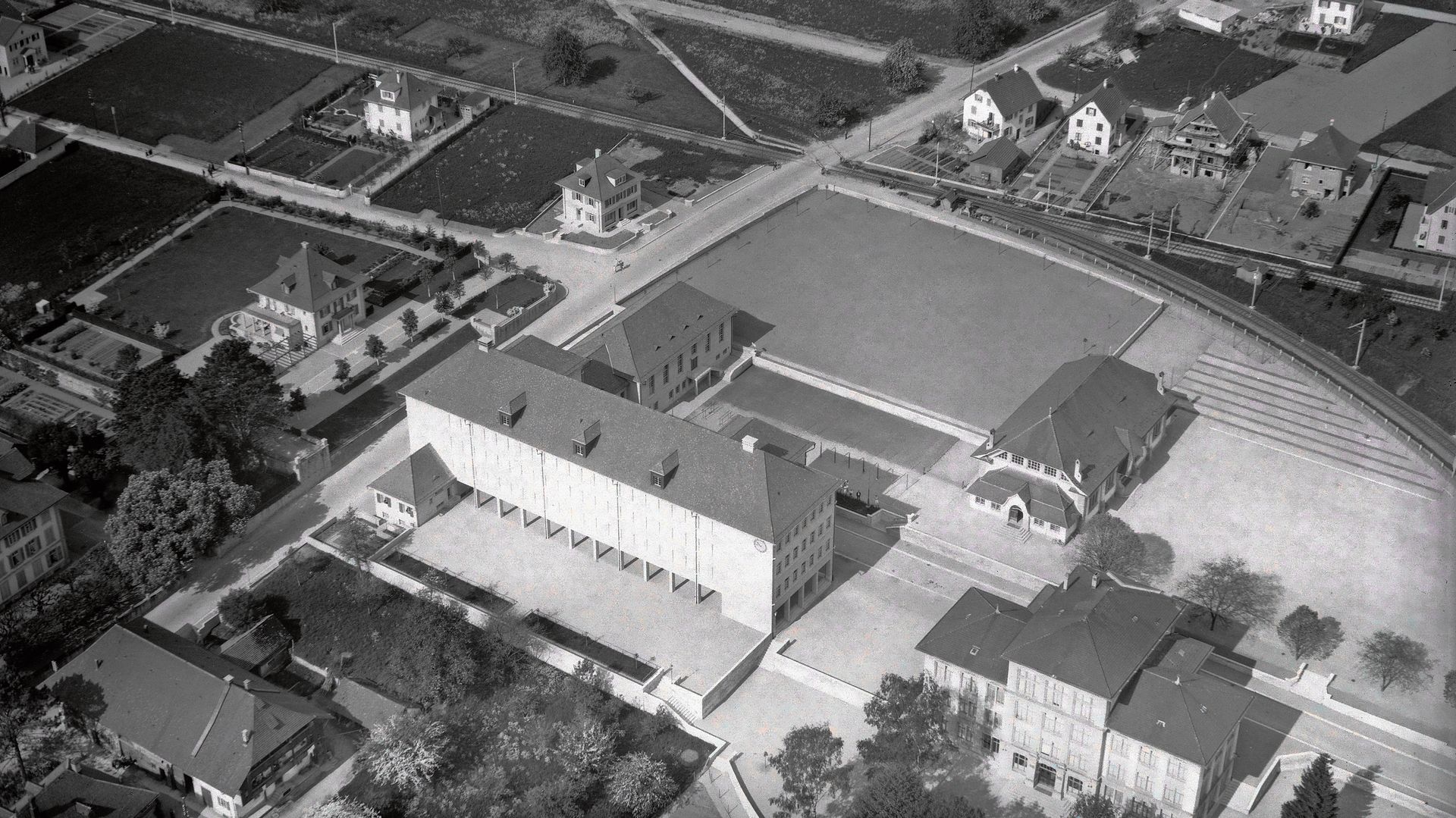 Luftaufnahme der Spitzkehre beim Schulareal Angelrain und Bahnübergang Aarauerstrasse 1931.Foto: ETH-Bibliothek Zürich, Bildarchiv/Stiftung Luftbild Schweiz Luftaufnahme der Spitzkehre beim Schulareal Angelrain und Bahnübergang Aarauerstrasse 1931.Foto: ETH-Bibliothek Zürich, Bildarchiv/Stiftung Luftbild Schweiz