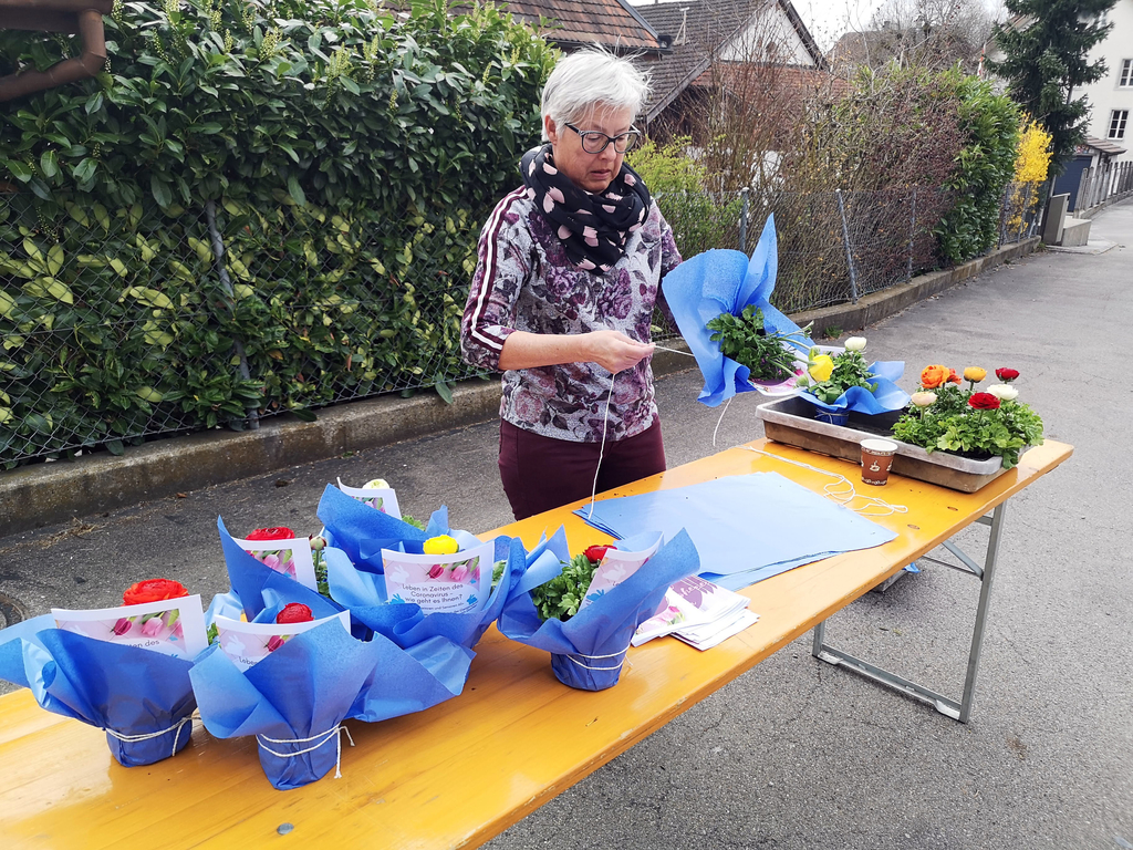 Schön verpackt und mit einem Gruss der Gemeinde versehen: Helferin beim Zusammenstellen eines Birrwiler Blumengrusses. Foto: Fritz Thut
