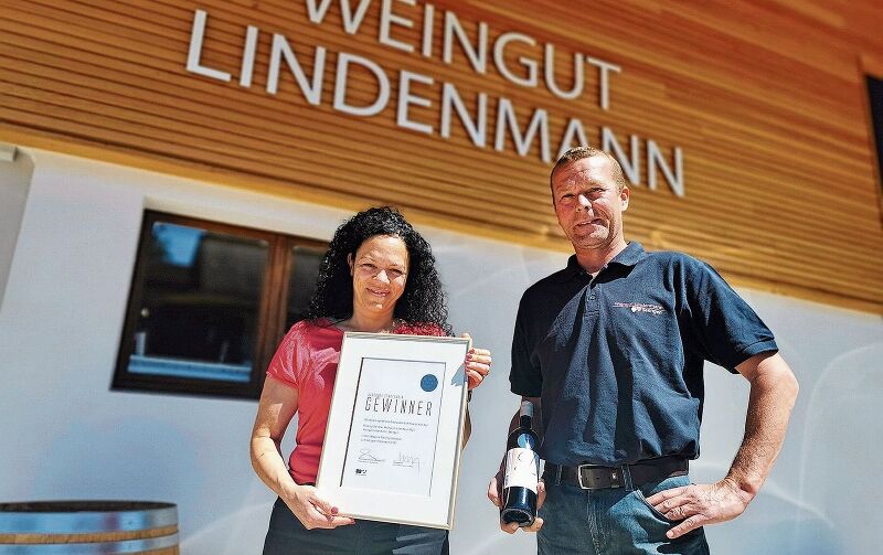 Stolz auf die Auszeichnung: Christina und Thomas Lindenmann mit Gewinnerurkunde und einer Flasche Aargauer Staatswein. Foto: Fritz Thut
