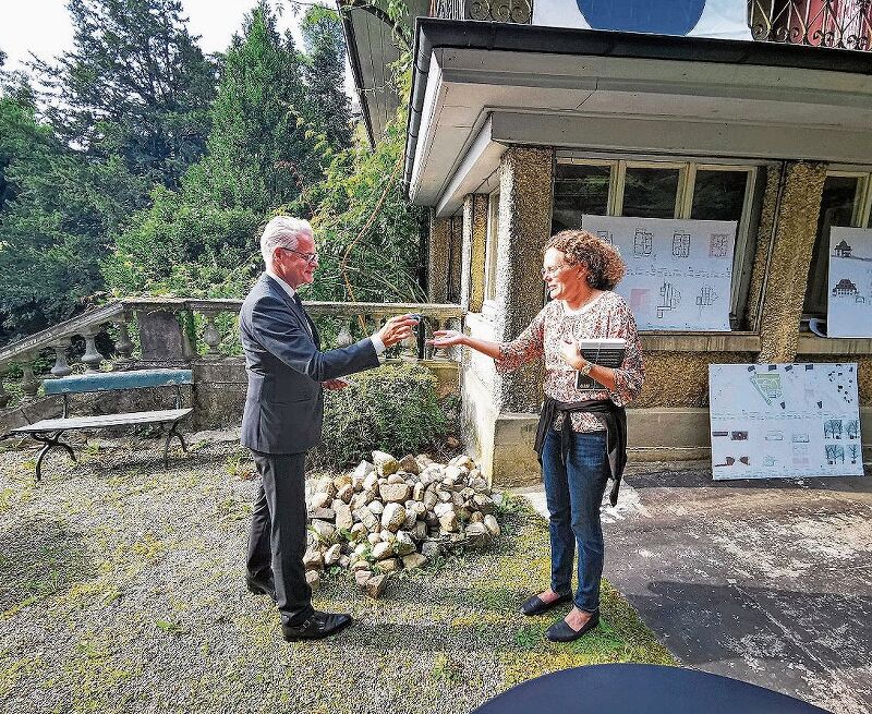 Eine Anzahlung: Der Kantonale Denkmalpfleger Reto Nussbaumer überreicht Villa-Sonnenberg-Besitzerin Christine von Arx einen alten Zweiräppler. Foto: Fritz Thut