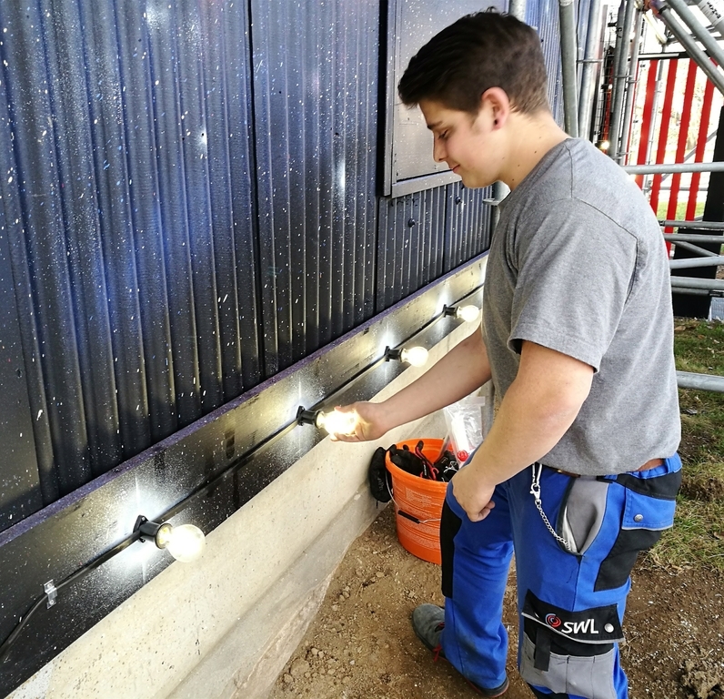 Es werde Licht: Ein Elektriker montiert und kontrolliert Glühlampen bei der Aussenbeleuchtung.
