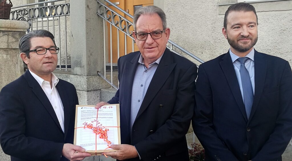 2120 Unterschriften für Erhalt der Poststelle: Vincenzo Pierdomenico, Leiter Region Aargau von der Post, übernimmt von Gemeindeammann Peter Lenzin die Petition, rechts André Aregger, Post-Netzentwicklung. Foto: Fritz Thut
