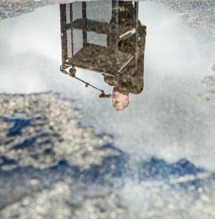 Steht Kopf: Regierungsrat Stephan Attiger spiegelt sich in einer Wasserpfütze. Foto: Chris Iseli