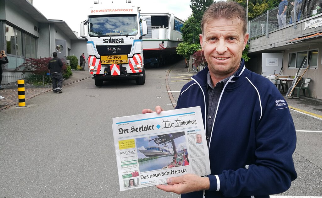 <em>Letzte Etappe an Land:</em> Ueli Haller, Geschäftsführer der Schifffahrtsgesellschaft, präsentiert am Tag der Einwasserung vor der MS 2018 die Titelseite dieser Zeitung. Fotos: Fritz Thut
